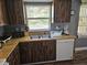 Kitchen featuring wood cabinets, stainless steel sink, and essential appliances at 1174 Victoria Ave, Port Charlotte, FL 33948