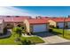 Charming villa featuring a vibrant red metal roof, an attached garage, and a well-manicured lawn at 1780 Deborah Dr # 15, Punta Gorda, FL 33950