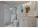 Bright bathroom with a glass-enclosed shower, updated vanity, and a round mirror at 18147 Cadillac Ave, Port Charlotte, FL 33948