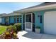 Charming home exterior featuring a screened entrance, blue accents, and a well-manicured garden at 18147 Cadillac Ave, Port Charlotte, FL 33948
