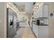 Well-lit kitchen with modern stainless steel appliances, white cabinets, and an open floor plan at 18147 Cadillac Ave, Port Charlotte, FL 33948