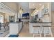 Modern kitchen with white cabinets, black countertops, a breakfast bar, and a seamless transition to outdoor dining at 18147 Cadillac Ave, Port Charlotte, FL 33948