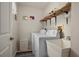 Functional laundry room with a washer, dryer, utility sink, and storage shelves at 18147 Cadillac Ave, Port Charlotte, FL 33948