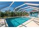 Inviting in-ground screened-in pool surrounded by lush landscaping and a spacious deck at 18147 Cadillac Ave, Port Charlotte, FL 33948