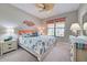 Comfortable bedroom with neutral walls, a ceiling fan, and nautical-themed decorations and bedding at 24109 Spartina Dr, Venice, FL 34293