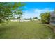 Spacious backyard showing a lush green lawn, a white fence, and a shed near the lanai at 3255 Lake View Blvd, Port Charlotte, FL 33948