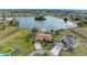 Aerial view of a waterfront property with a screened pool, lush landscaping, and proximity to a tranquil lake at 1115 Venture Ct, Punta Gorda, FL 33983