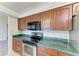 This kitchen features stainless steel appliances, wood cabinets, and tile flooring at 1115 Venture Ct, Punta Gorda, FL 33983