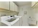Laundry room features a washer, dryer, storage cabinets and utility sink at 1115 Venture Ct, Punta Gorda, FL 33983