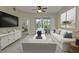 Comfortable living room with a large flat-screen TV, plush white seating, and access to the outdoor patio at 240 W End Dr # 412, Punta Gorda, FL 33950