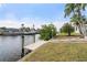 Scenic waterfront backyard featuring a private boat dock and lush tropical landscaping at 5430 Almar Dr, Punta Gorda, FL 33950