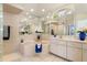 Bright bathroom with a tub, white cabinets, tiled flooring, and a large mirror, creating a spa-like atmosphere at 5430 Almar Dr, Punta Gorda, FL 33950