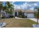 Charming single-story home featuring a well-manicured lawn, elegant landscaping, and a welcoming double-door entry at 5430 Almar Dr, Punta Gorda, FL 33950
