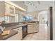 Well-lit kitchen with a counter bar, a view of the screened-in patio and stainless steel appliances at 5430 Almar Dr, Punta Gorda, FL 33950