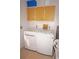 Functional laundry room with modern washer and dryer, along with overhead storage cabinets at 721 Brenda Ct, Punta Gorda, FL 33950