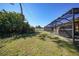 Spacious grassy backyard featuring a screened-in patio area, ideal for outdoor living and relaxation at 18395 Edgewater Dr, Port Charlotte, FL 33948