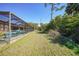 Expansive backyard with lush green grass and a screened-in pool area, perfect for outdoor enjoyment at 18395 Edgewater Dr, Port Charlotte, FL 33948