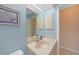Well lit bathroom featuring light blue walls, tile floors, and a large mirror at 18395 Edgewater Dr, Port Charlotte, FL 33948
