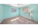 Bright bedroom with light blue walls, neutral carpet, and two windows providing natural light at 18395 Edgewater Dr, Port Charlotte, FL 33948