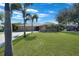 Inviting single-story home boasts a lush green lawn and mature palm trees at 18395 Edgewater Dr, Port Charlotte, FL 33948