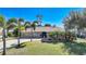 Charming single-story home featuring well-manicured lawn, mature palms and stone accents at 18395 Edgewater Dr, Port Charlotte, FL 33948