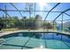 Gorgeous screened pool with clear blue water and surrounding lush greenery at 18395 Edgewater Dr, Port Charlotte, FL 33948