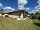 Backyard of home featuring screen door, partial grass and cloudy skies at 24157 Green Heron Dr # 27, Punta Gorda, FL 33980