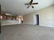 A well-lit living room features an open floor plan with neutral carpeting and a ceiling fan at 24157 Green Heron Dr # 27, Punta Gorda, FL 33980