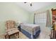 Comfortable bedroom with tile flooring, ceiling fan, natural light, and a cozy armchair at 483 Winwood Ct, Port Charlotte, FL 33954