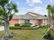 Beautiful front exterior of home with vibrant landscaping, an attached garage, and a well-manicured lawn at 483 Winwood Ct, Port Charlotte, FL 33954
