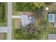 An aerial shot displays the house with a screened pool in a tranquil, tree-lined suburban location at 5452 Montego Ln, Port Charlotte, FL 33981