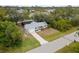 Aerial view of the home showing a lush green yard, long driveway, and a screened-in pool at 5452 Montego Ln, Port Charlotte, FL 33981