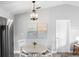 Bright dining area with modern chandelier, table, and chairs, next to the stainless steel refrigerator at 5452 Montego Ln, Port Charlotte, FL 33981