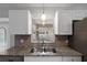 Kitchen sink beneath a window offers a view of the pool, with white cabinets and granite countertops at 5452 Montego Ln, Port Charlotte, FL 33981