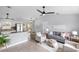 Bright living room open to kitchen, features modern furniture and decor, and ceiling fan at 5452 Montego Ln, Port Charlotte, FL 33981