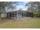 Backyard pool with a screened enclosure, surrounded by trees and greenery at 5452 Montego Ln, Port Charlotte, FL 33981