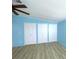 Bedroom featuring three large closets and light wood-look flooring at 6642 Acacia Ct, North Port, FL 34287