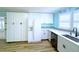 Bright kitchen with white cabinets, wood flooring, stainless appliances, and lots of natural light at 6642 Acacia Ct, North Port, FL 34287