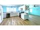 Bright kitchen with white cabinets, stainless appliances, wood flooring, and open floor plan at 6642 Acacia Ct, North Port, FL 34287