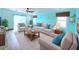 Bright living room with coastal decor, ceiling fan, and sliding glass doors at 6642 Acacia Ct, North Port, FL 34287