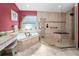 Well-lit bathroom features a glass enclosed shower, a tub, granite counters, and tan colored tile at 2275 Kenya Ln, Punta Gorda, FL 33983