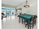 Dining area with a decorative light fixture, tile flooring, and sliding glass doors to the screened lanai at 2275 Kenya Ln, Punta Gorda, FL 33983