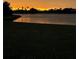 Scenic lake view at sunset with vibrant colors reflecting off the water and lush greenery in the foreground at 2275 Kenya Ln, Punta Gorda, FL 33983
