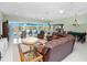 Bright living room with tile floors, ceiling fans, lake views, and access to the screened-in pool at 2275 Kenya Ln, Punta Gorda, FL 33983