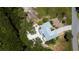 Aerial view of a single-Gathering home featuring a metal roof, driveway, and mature landscaping at 24362 Yacht Club Blvd, Punta Gorda, FL 33955