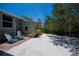 Backyard with outdoor storage shed, mature trees, and pea gravel, offering a private outdoor space at 24362 Yacht Club Blvd, Punta Gorda, FL 33955