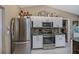 Bright kitchen featuring white cabinetry, stainless steel appliances, and a mosaic tile backsplash at 24362 Yacht Club Blvd, Punta Gorda, FL 33955