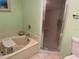 Bathroom with a tub, shower door, and ample space at 25188 Marion Ave # F201, Punta Gorda, FL 33950