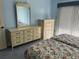 Bright bedroom with large dressers and a floral patterned bedspread, creating a charming and comfortable space at 25188 Marion Ave # F201, Punta Gorda, FL 33950