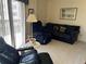 Relaxing living room with a cozy navy sofa and recliner, perfect for unwinding and enjoying quiet moments at 25188 Marion Ave # F201, Punta Gorda, FL 33950